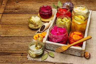 Cam kavanozlarda mayalanmış sebzeler. Mevsimlik sebze konsepti, sağlıklı yaşam tarzı için probiyotik gıdası. Eski tahta tablo, kopyala alanı