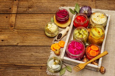 Cam kavanozlarda mayalanmış sebzeler. Mevsimlik sebze konsepti, sağlıklı yaşam tarzı için probiyotik gıdası. Kaliteli ahşap masa, üst manzara