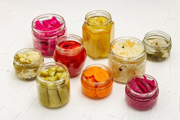 Cam kavanozlarda mayalanmış sebzeler. Mevsimlik sebze konsepti, sağlıklı yaşam tarzı için probiyotik gıdası. Beyaz macun arkaplanı, kopyalama alanı