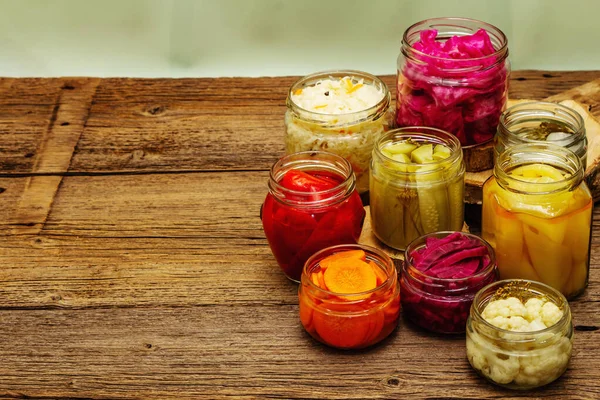 Cam kavanozlarda mayalanmış sebzeler. Mevsimlik sebze konsepti, sağlıklı yaşam tarzı için probiyotik gıdası. Eski tahta tablo, kopyala alanı