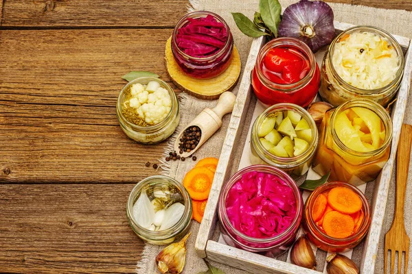 Cam kavanozlarda mayalanmış sebzeler. Mevsimlik sebze konsepti, sağlıklı yaşam tarzı için probiyotik gıdası. Kaliteli ahşap masa, üst manzara