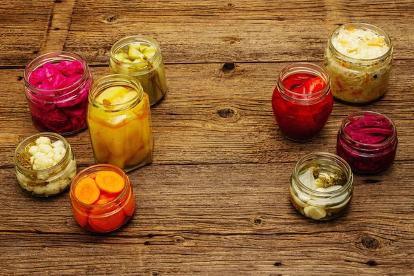 Cam kavanozlarda mayalanmış sebzeler. Mevsimlik sebze konsepti, sağlıklı yaşam tarzı için probiyotik gıdası. Eski tahta tablo, kopyala alanı