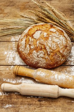 Buğday kulaklı ve okkalı taze ekmek. Eski ahşap tahta masa, hamur yoğurma, kopyalama alanı