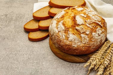 Buğday kulaklı taze ekmek ve kaliteli keten peçete. Gri taş beton zemin, kopyalama alanı