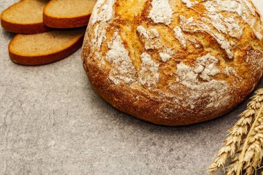 Buğday kulaklı taze ekmek ve kaliteli keten peçete. Gri taş beton arka plan, kapat