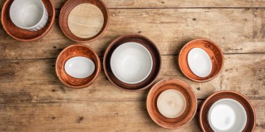 El yapımı boş seramik tabaklar ve ahşap kaplama tabaklar. Çeşitli kase koleksiyonları, geleneksel halk süsleri, kırsal stil, klasik masa. Hamursuz Bayramı masa konsepti, Banner