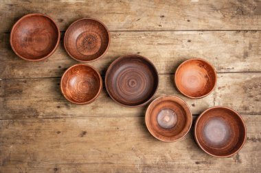 El yapımı boş seramik tabaklar ve ahşap kaplama tabaklar. Çeşitli kase koleksiyonları, geleneksel halk süsleri, kırsal stil, klasik masa. Hamursuz Bayramı masa konsepti, üst görünüm