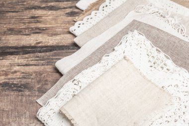 Eski kumaş parçalarının koleksiyonu. Çeşitli tekstil türleri, hobi, sanat veya zanaat konsepti. Eski tahta masa, boşluğu kopyala