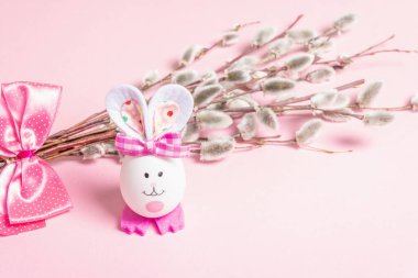 Söğüt tozu, pastel pembe arka planda izole edilmiş. Söğüt fokları, tüylü tomurcuklar, yumurtadan çıkan el yapımı komik tavşan. Mutlu Paskalyalar