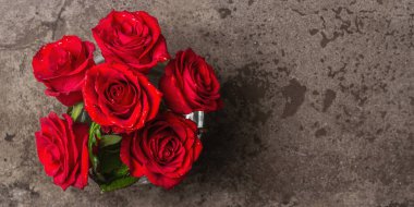 Vazoda bir buket taze kırmızı gül. Düğünler, doğum günleri, 8 Mart, anneler günü ya da sevgililer günü için festival konsepti. Tebrik kartı, koyu mermer arkaplan, Banner