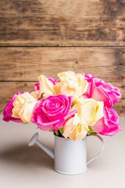 Sulama kabında bir buket taze renkli gül. Düğünler, doğum günleri, 8 Mart, anneler günü ya da sevgililer günü için festival konsepti. Tebrik kartı, hafif arkaplan