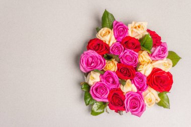 Seramik standında çok renkli taze güllerin kompozisyonu. Düğünler, doğum günleri, 8 Mart, anneler günü ya da sevgililer günü için festival konsepti. Tebrik kartı, düz yatış, taş zemin