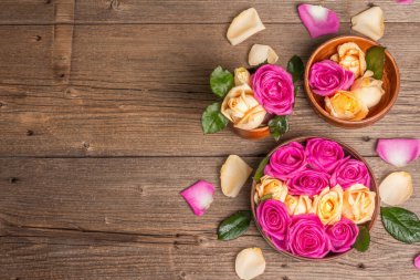 Mutfak gereçlerinde çok renkli taze güllerin bileşimi. Düğünler, doğum günleri, 8 Mart, anneler günü ya da sevgililer günü için festival konsepti. Tebrik kartı, düz yatak, eski ahşap masa.