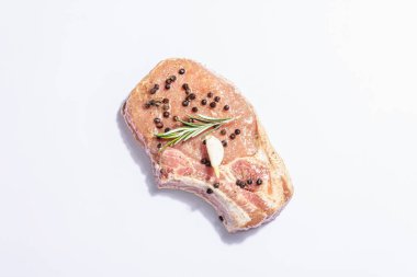 Beyaz arka planda çiğ domuz filetosu. Taze sarımsak, kokulu biberiye, karabiber, deniz tuzu. Modern sert bir ışık, karanlık bir gölge, düz uzanma, model, şablon