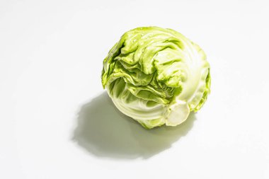 Taze taze lahana, tüm kafa beyaz arka planda izole edilmiş. Modern sert ışık, karanlık gölge. Bahar salatası kesmek için sebzeler. Vejetaryen yemeği, diyet, vitamin