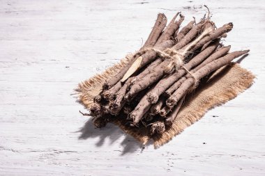 Bir demet çiğ Scorzonera ya da İspanyol tuzlusu. Modern sebzeler, sağlıklı yiyecekler, şeker hastaları için uygun. Modaya uygun bir sert ışık, karanlık gölge, boşluğu kopyala