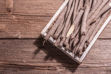 Çiğ Scorzonera ya da İspanyol tuzunu bir sandıkta. Modern sebzeler, sağlıklı yiyecekler, şeker hastaları için uygun. Modaya uygun sert bir ışık, karanlık bir gölge, ahşap masa, üst manzara.