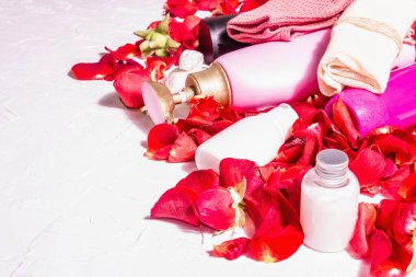Rose ile doğal kozmetik. Çeşitli şişeler, taze yapraklı spa konsepti. Modern sert ışık, karanlık gölge. Sağlıklı self-bakım, organik malzemeler. Beyaz alçı arkaplan, metin için yer