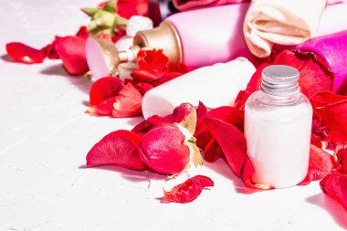 Rose ile doğal kozmetik. Çeşitli şişeler, taze yapraklı spa konsepti. Modern sert ışık, karanlık gölge. Sağlıklı self-bakım, organik malzemeler. Beyaz alçı arkaplan, metin için yer