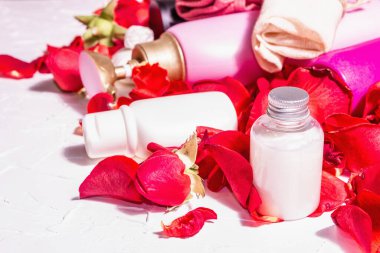 Rose ile doğal kozmetik. Çeşitli şişeler, taze yapraklı spa konsepti. Modern sert ışık, karanlık gölge. Sağlıklı self-bakım, organik malzemeler. Beyaz alçı arkaplan, metin için yer