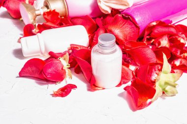 Rose ile doğal kozmetik. Çeşitli şişeler, taze yapraklı spa konsepti. Modern sert ışık, karanlık gölge. Sağlıklı self-bakım, organik malzemeler. Beyaz alçı arkaplan, metin için yer