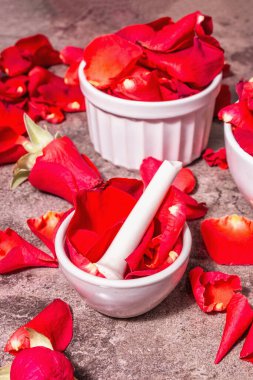 Gül yapraklı gül suyu. Kerala Hindistan 'ı pişirmek için organik gül özü yapıyorum. Aromaterapi, spa rahatlama, kozmetik konsepti. Modern sert ışık, karanlık gölge. Taş arkaplan, kopyalama alanı