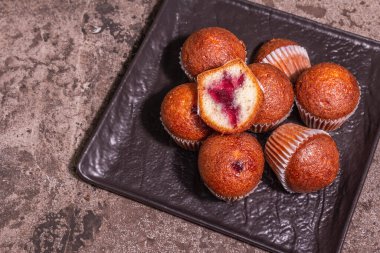 Kurabiyeler frenk üzümü reçeli doldurdu. Modern sert ışık, karanlık gölge. Seramik standı, taş beton zemin, üst manzara