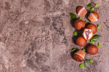 Kurabiyeler frenk üzümü reçeli doldurdu. Modern sert ışık, karanlık gölge. Seramik standı, taş beton zemin, üst manzara