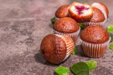 Kurabiyeler frenk üzümü reçeli doldurdu. Modern sert ışık, karanlık gölge. Seramik standı, taş beton zemin, metin için yer