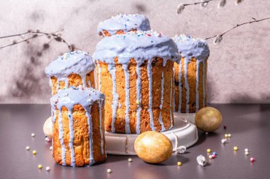 Mavi kremalı, üzeri yenebilir boncuklu Paskalya pastası. Doğal sağlıklı malzemeler, altın yumurtalar, şenlikli dekorasyon. Modern stantlar, modaya uygun aydınlık, karanlık gölge. Taş beton arkaplan, kopyalama alanı