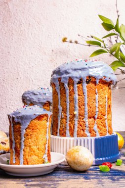 Mavi kremalı, üzeri yenebilir boncuklu Paskalya pastası. Doğal sağlıklı malzemeler, altın yumurtalar, şenlikli dekorasyon. Modern stantlar, eski ahşap masa, kopyalama alanı