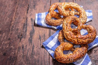 Oktoberfest konsepti: Geleneksel peçetede krakerler. Modaya uygun sert ışık, karanlık gölge. Antika tahta tahta arka plan, kopyalama alanı