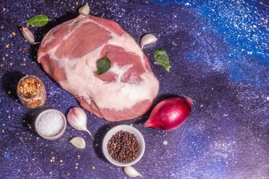 Çiğ domuz omzu kesiği. Taze hayvan proteini, baharatlar, sebzeler. Modaya uygun sert ışık, karanlık gölge. Kozmik taş arkaplan, üst görünüm