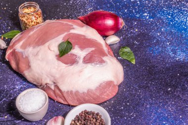 Çiğ domuz omzu kesiği. Taze hayvan proteini, baharatlar, sebzeler. Modaya uygun sert ışık, karanlık gölge. Kozmik taş arkaplan, kopyalama alanı