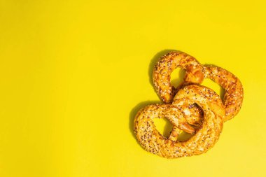 Oktoberfest konsepti - krakerler sarı arka planda izole edilmiş. Modaya uygun bir aydınlık, karanlık gölge, üst manzara.