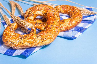 Oktoberfest konsepti: Geleneksel peçetede krakerler. Modaya uygun sert ışık, karanlık gölge. Pastel mavi arkaplandaki dikenler, metin için yer