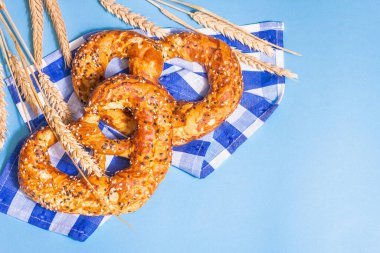 Oktoberfest konsepti: Geleneksel peçetede krakerler. Modaya uygun sert ışık, karanlık gölge. Pastel mavi arkaplanda dikenler, üst görünüm