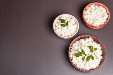 Seramik kasede süzme peynir. Derin bir tabakta ev yapımı süt ürünü. Taş beton zemin, üst manzara, düz zemin