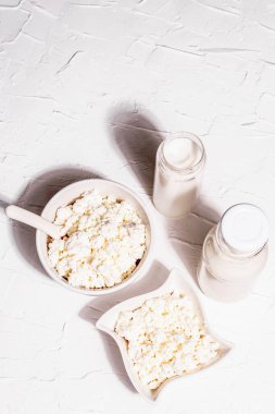 Seramik kasede içinde süt olan süzme peynir. Derin bir tabakta ev yapımı süt ürünü. Beyaz macun arkaplan, üst görünüm