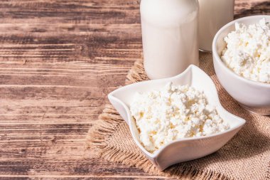 Seramik kasede içinde süt olan süzme peynir. Derin bir tabakta ev yapımı süt ürünü. Eski tahta masa, boşluğu kopyala