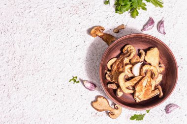 Kurutulmuş mantar Boletus edulis (Penny bun, Cep, Porcini) dokulu alçı arka planda. Vejetaryen (vejetaryen) sağlıklı yiyecekler için. Modaya uygun bir aydınlık, karanlık gölge, üst manzara.