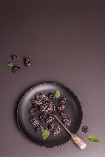 セラミックプレート上のブラックベリー 健康的な食事のための冷凍果物 ミニマルなコンセプト ブラックストーンコンクリートの背景 トップビュー — ストック写真