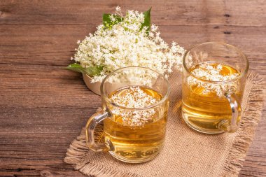 Mürver çiçeği çayı. Taze yaz içkisi, sağlıklı yaşam tarzı konsepti. Kumaş peçete, eski ahşap masa, kopyalama alanı