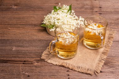 Mürver çiçeği çayı. Taze yaz içkisi, sağlıklı yaşam tarzı konsepti. Kumaş peçete, eski ahşap masa, kopyalama alanı