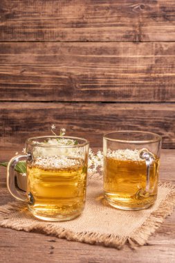 Mürver çiçeği çayı. Taze yaz içkisi, sağlıklı yaşam tarzı konsepti. Kumaş peçete, eski ahşap masa, kopyalama alanı