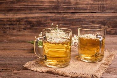 Mürver çiçeği çayı. Taze yaz içkisi, sağlıklı yaşam tarzı konsepti. Kumaş peçete, eski ahşap masa, kopyalama alanı