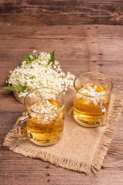 Mürver çiçeği çayı. Taze yaz içkisi, sağlıklı yaşam tarzı konsepti. Kumaş peçete, eski ahşap masa, kopyalama alanı