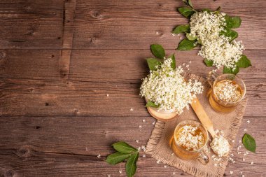 Mürver çiçeği çayı. Taze yaz içkisi, sağlıklı yaşam tarzı konsepti. Kumaş peçete, eski ahşap masa, üst manzara.