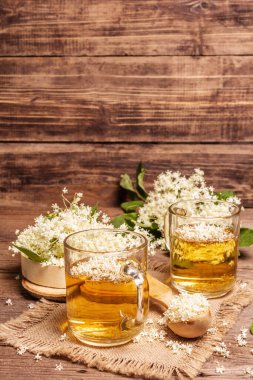 Mürver çiçeği çayı. Taze yaz içkisi, sağlıklı yaşam tarzı konsepti. Kumaş peçete, eski ahşap masa, kopyalama alanı