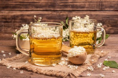 Mürver çiçeği çayı. Taze yaz içkisi, sağlıklı yaşam tarzı konsepti. Kumaş peçete, eski ahşap masa, kapatın.